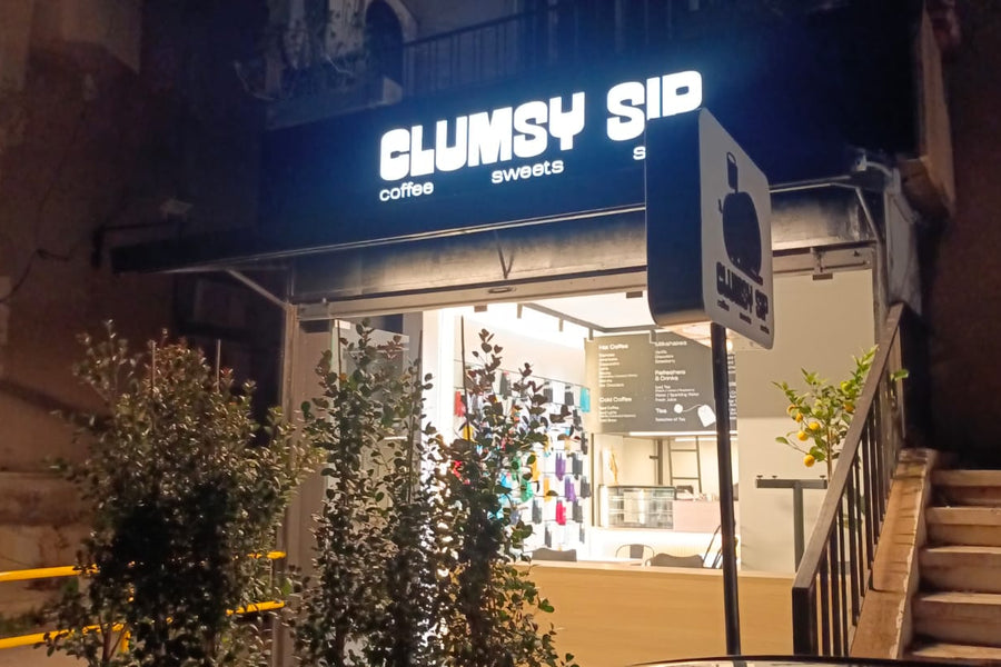 Clumsy Sips storefront at night